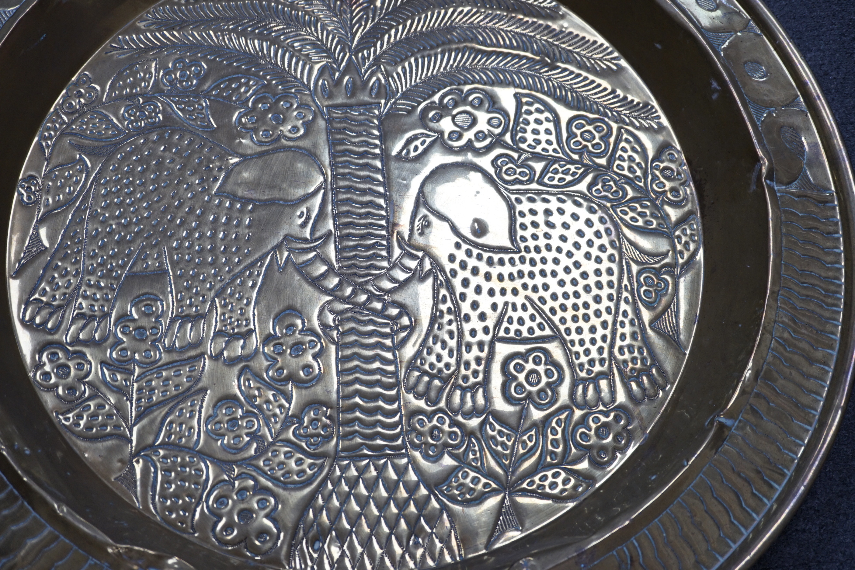 An embossed brass table top/ tray, 74cm diameter